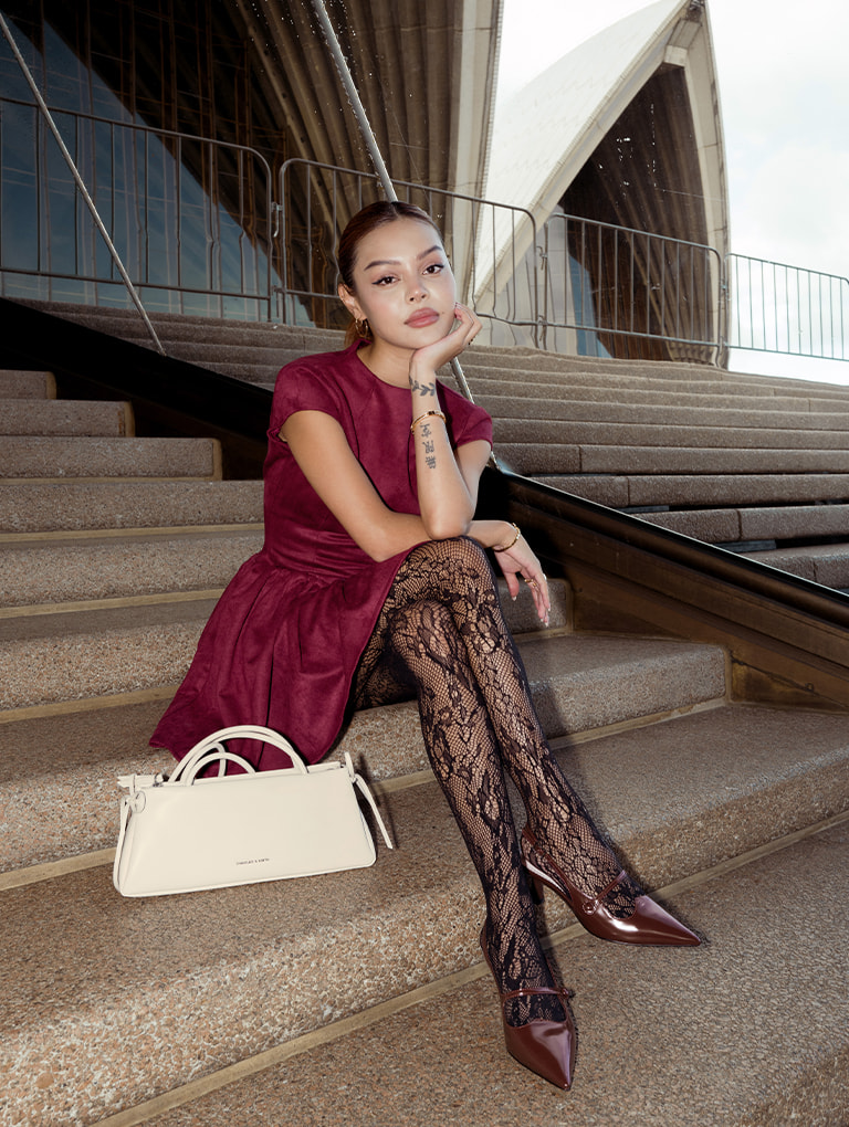 Women’s bow elongated trapeze shoulder bag in meringue white & pointed-toe Mary Jane slingback pumps in burgundy, as seen on Lily May Mac – CHARLES & KEITH