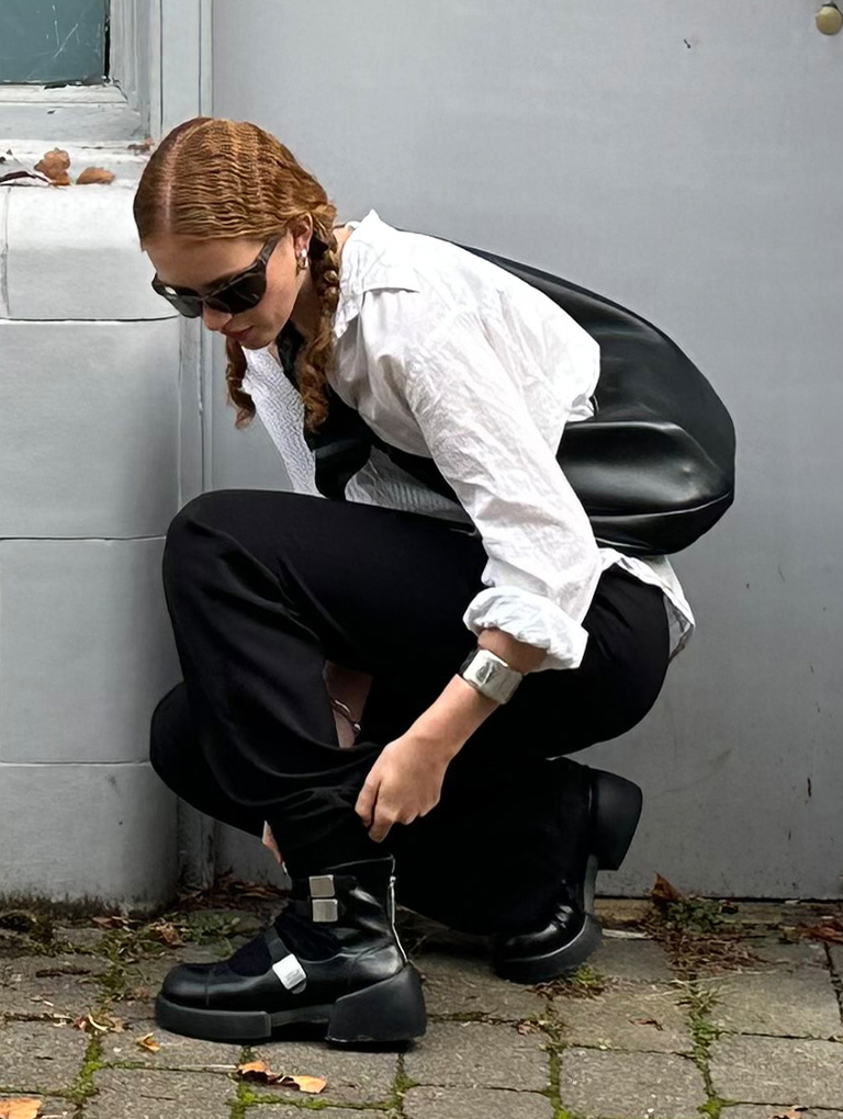 Women’s Toni knotted curved hobo bag in noir & Robbie ankle-strap Mary Jane boots in black, as seen on Sadie - CHARLES & KEITH